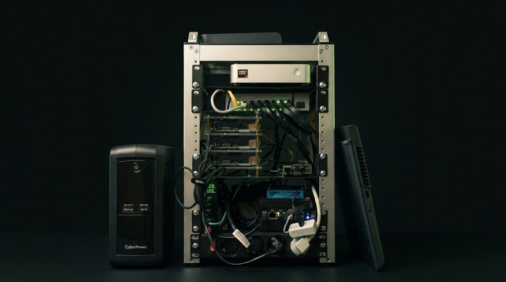 The DataHub.local cluster, a seven-node mini-PC rack in a dark studio setting